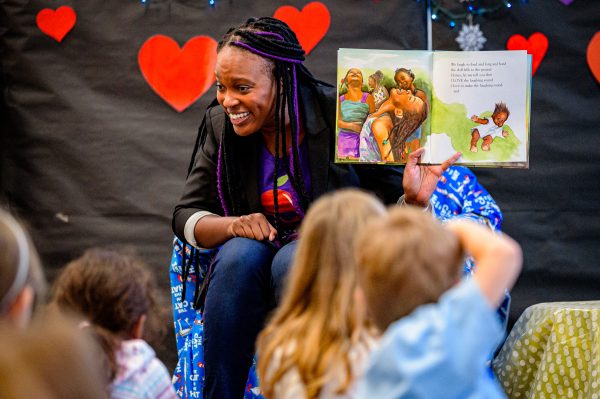 A woman reading to a class of young children as befitting the Early Care and Education Apprenticeship program.