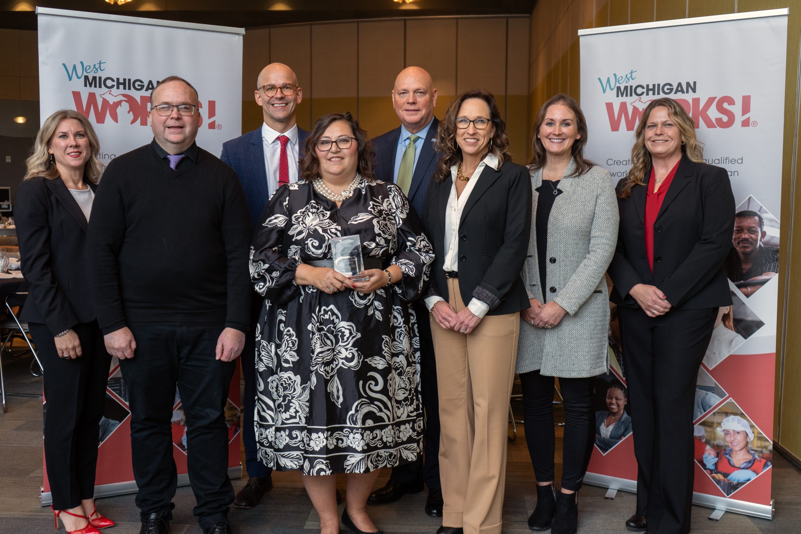 Winners of the West Michigan Works! 2024 Partner of the Year Award gather with staff .